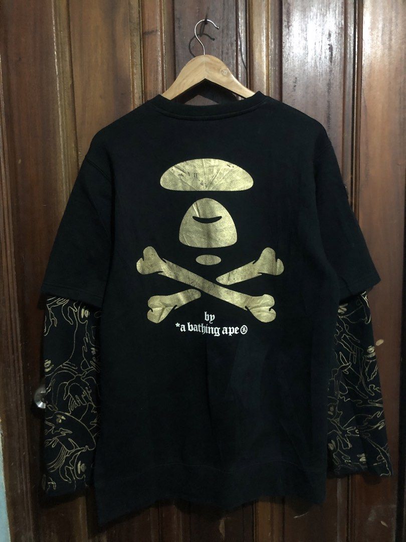 AAPE By A Bathing Ape Black Double Sleeve Sweatshirt (Category: Coats, Jackets and Outerwear) located in Quezon City. Submitted by yeahsource222 (Listing ID 1467530431, Image 2). Description: - Brand: AAPE (By A Bathing Ape) - Color: Black with gold details - Design: Layered short-sleeve overlay on long sleeves - Graphics: Gold foil AAPE text on front, large ape head skull logo on back, and 'apes and planet earth' lettering on chest - Details: Go