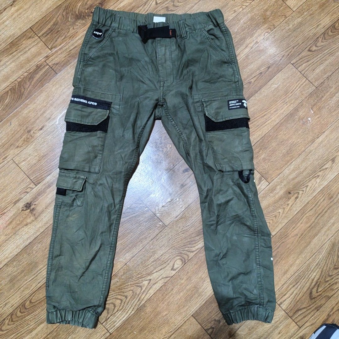 AAPE By A Bathing Ape Green Cargo Pants (Category: Joggers) located in Manila. Submitted by narju1234 (Listing ID 1467370132, Image 2). Description: - Brand: AAPE by A Bathing Ape (Nowhere Co., Ltd.) - Color: Green - Material: 100% Cotton - Waist: Elastic waistband with built-in adjustable belt - Pockets: Multiple leg pockets featuring iconic Ape & Planet Earth patches and text prints - Cuffs: Ribbed ankle cuffs for a secure, tapered fit - Condit