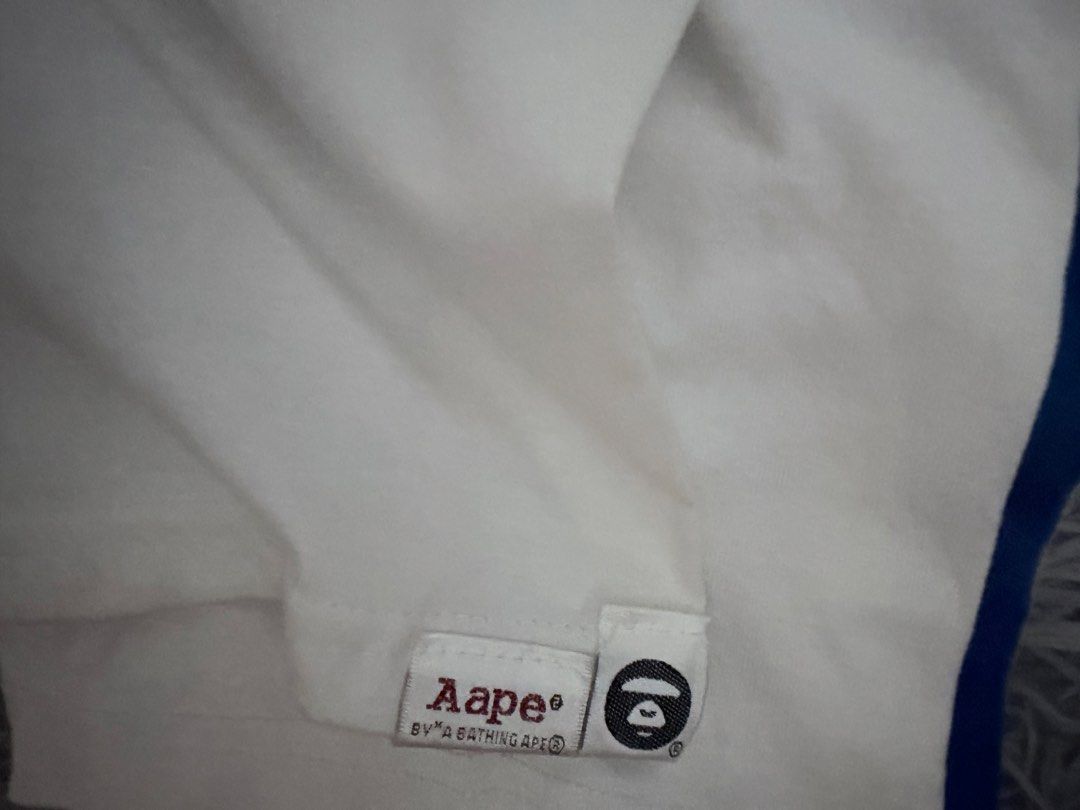 AAPE By A Bathing Ape White T-Shirt (Category: Tshirts & Polo Shirts ) located in Manila. Submitted by m1ggo (Listing ID 1467533376, Image 3). Description: - Brand: AAPE By A Bathing Ape - Color: White - Size: XL - Design: Large AAPE UNVS front graphic print - Details: Classic crew neck with branded inner taping and embroidered logo patch on the hem - Condition: Clean, great streetwear piece.