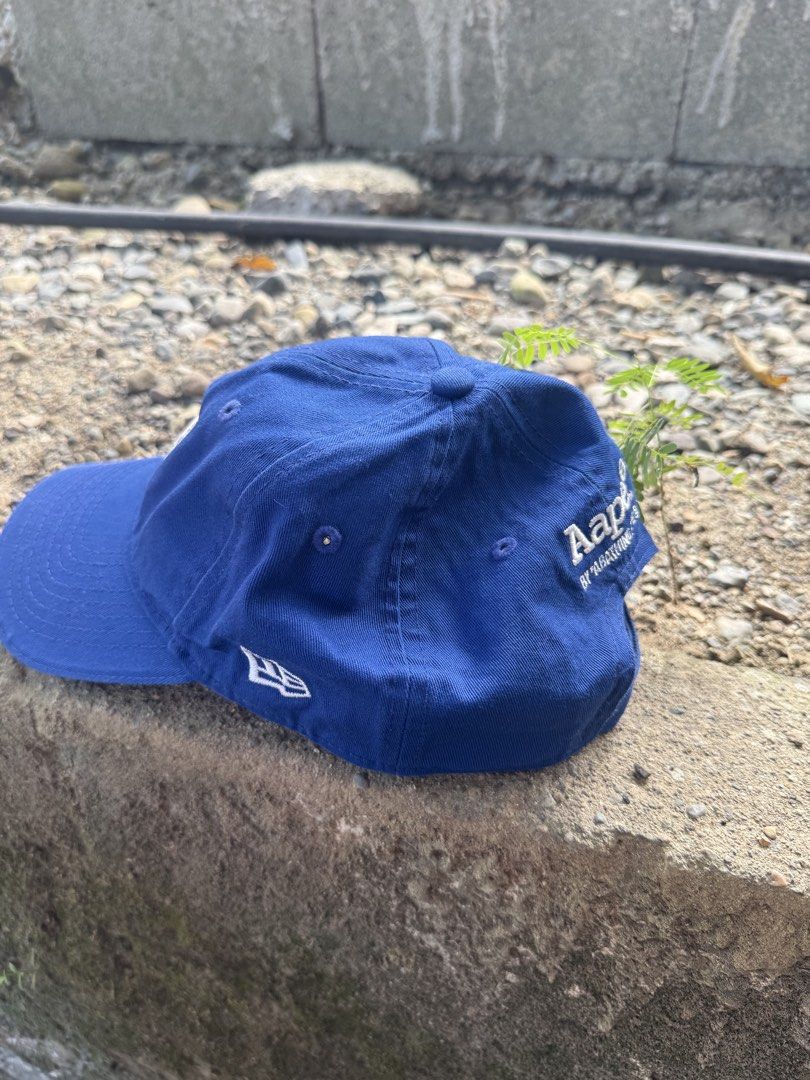 Aape x New Era 9TWENTY Blue Cap (Category: Caps & Hats) located in Burgos, Ilocos Norte. Submitted by copthrift (Listing ID 1467371686, Image 3). Description: - Official Aape x New Era collaboration - Style: Classic 9TWENTY adjustable strapback - Color: Royal Blue cotton - Details: White Aape front logo, New Era side embroidery, and back text branding - Authenticity: Includes original interior tags and brim holographic sticker - Size: One size fi