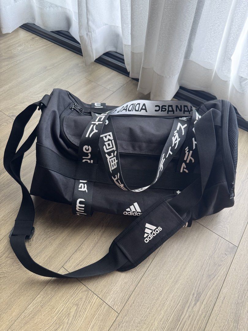 Adidas Black Duffel Bag Multi-Language Logo (Category: Sling Bags) located in Davao. Submitted by Tineeee. (Listing ID 1467372734, Image 1). Description: - Brand: Adidas - Color: Classic Black with bold global lettering straps - Condition: Clean inside and out, smooth-working zippers - Storage: Very spacious, perfect for gym gear, sports equipment, or weekend travel - Comfort: Includes dual carry handles and an adjustable, padded shoulder strap.