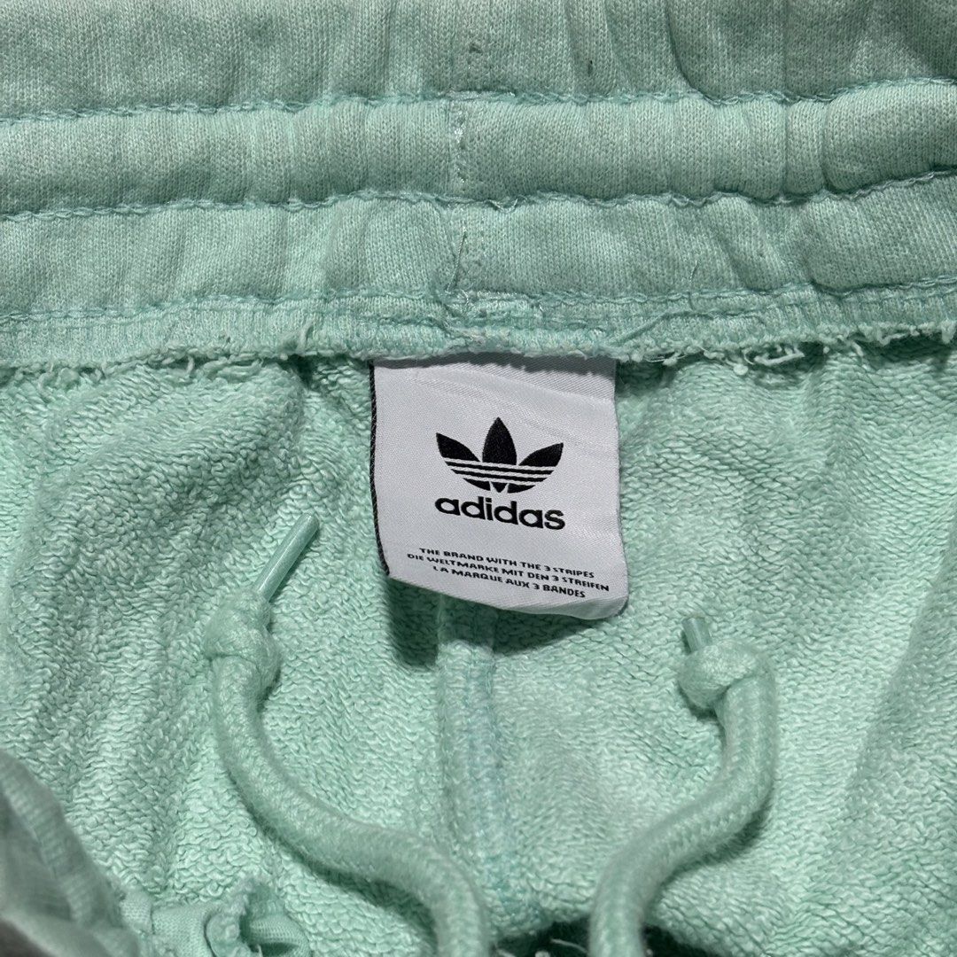 Adidas Mint Green Sweatshorts (Category: Shorts) located in Cebu City. Submitted by andrewvivar29 (Listing ID 1467443286, Image 3). Description: - Brand: Adidas - Color: Mint green - Style Code: H39974 - Material: Soft french terry inside - Features: Drawstring waistband, side pockets, embroidered Trefoil logo - Condition: Light wear with minor discoloration marks near the lower right leg - Ideal for casual lounging or workouts.