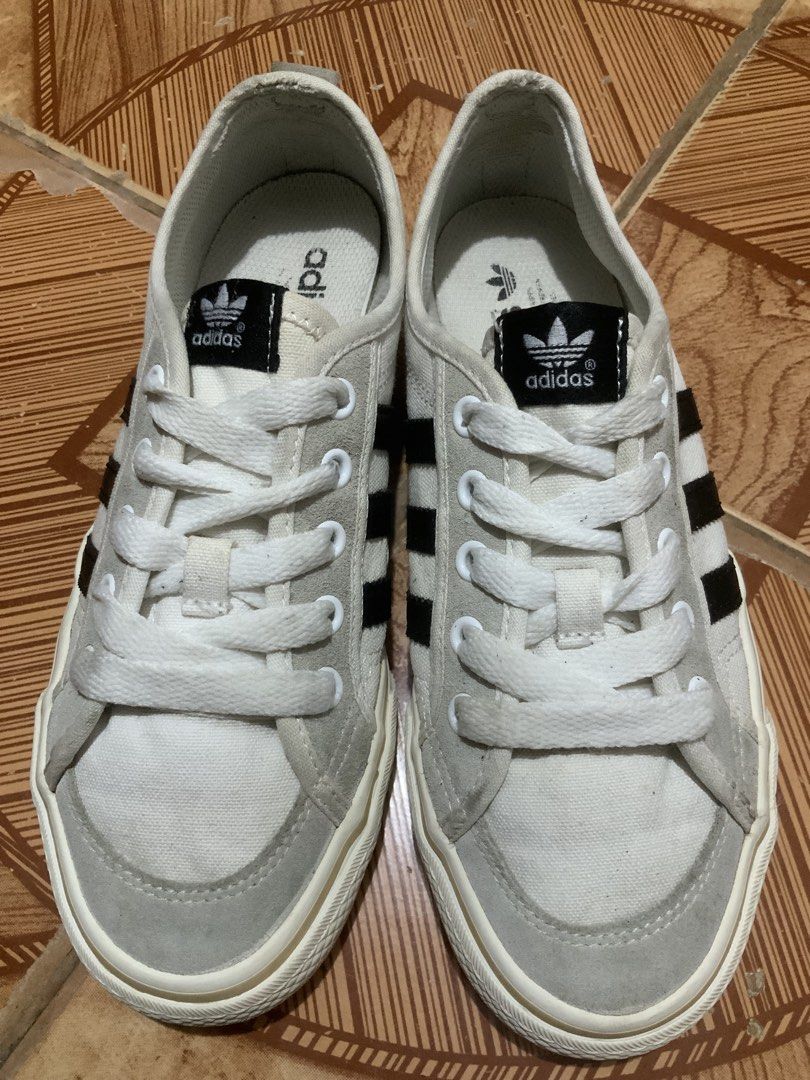 Adidas Nizza sneakers EU 38 (Category: Sneakers) located in Caloocan City. Submitted by Twinsters_2nd (Listing ID 1467448703, Image 2). Description: - Adidas Nizza low-top sneakers. - Off-white canvas upper with grey suede overlays and black three-stripes branding. - White laces and thick rubber midsoles showing mild yellowing from age. - Size EU 38, US5 - Clean overall shape with no major structural damage or heavy wear. - payment first, sh0pee 