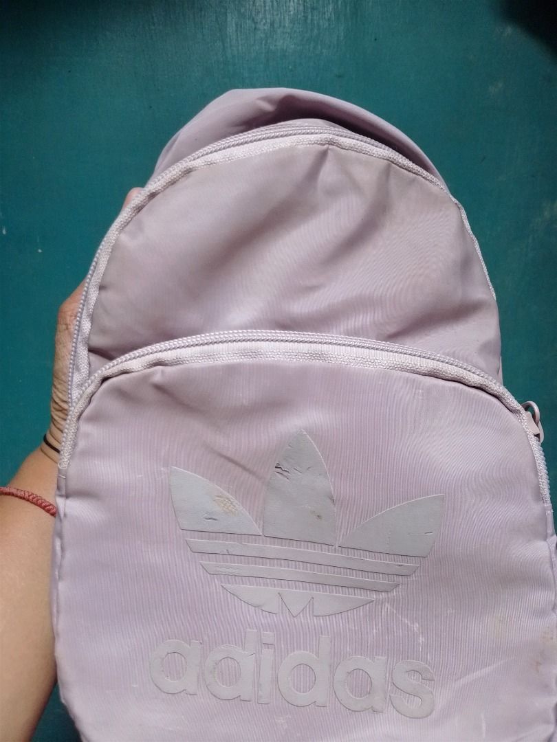 Adidas Original Pastel Purple Mini Backpack (Category: Backpacks) located in Caloocan City. Submitted by hmm_shop83 (Listing ID 1467441810, Image 3). Description: - Brand: Adidas - Color: Lilac Purple - Design: Classic trefoil logo with branded zip pull tabs - Features: Adjustable straps and secure zip closure - Origin: Made in Vietnam (RN 88387 CA 40312) - Condition: Compact size, perfect for daily commutes and casual outings.
