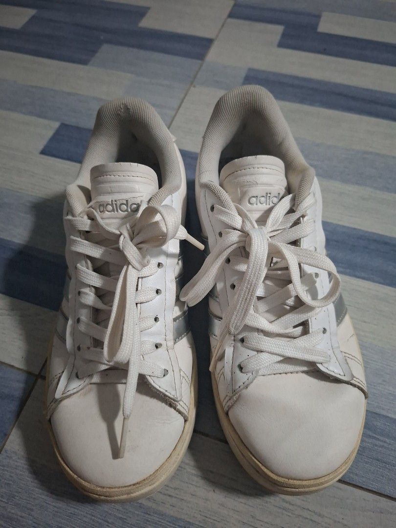 Adidas White Casual Sneaker (Category: Sneakers) located in Manila. Submitted by ninyagauri24333 (Listing ID 1467480435, Image 1). Description: - Brand/Model: Classic white Adidas sneakers with stylish silver stripes and laces - Comfort & Grip: Features padded ankle collars for extra comfort and textured rubber outsoles for good traction - Condition: Shows visible signs of wear on the leather uppers and soles, with slight peeling on the collar of
