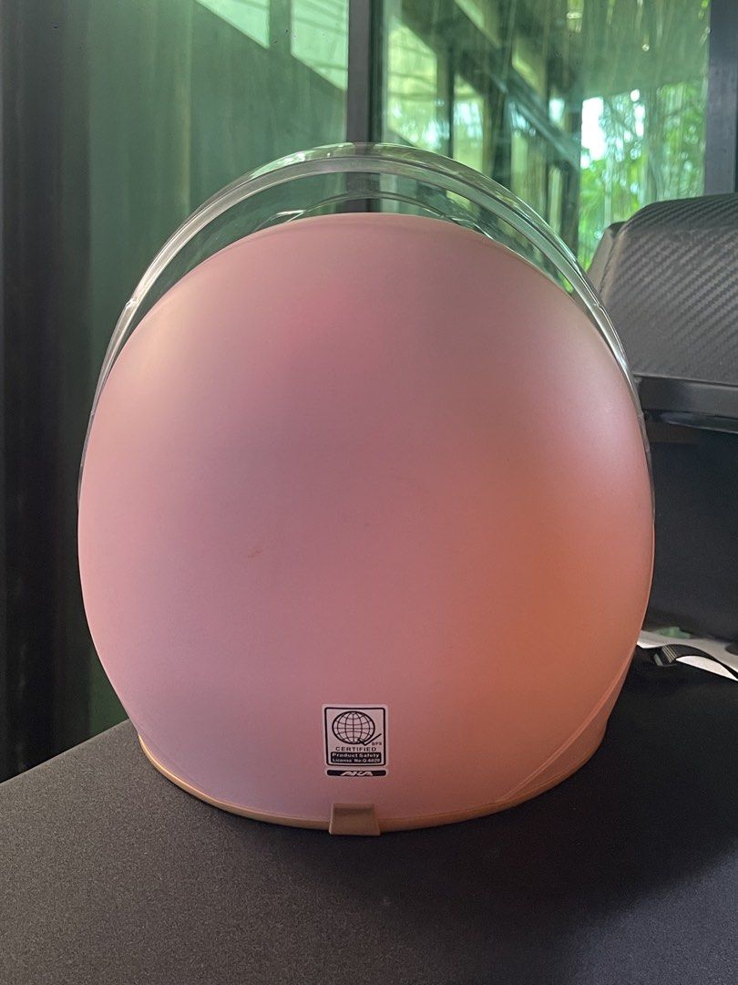 AKA Pink Motorcycle Half-Helmet with Clear Visor (Category: Bicycles) located in San Pablo. Submitted by vrmthrsainz (Listing ID 1467421395, Image 3). Description: - Brand: AKA Motorcycle Helmet - Color: Matte pink finish with stylish brown trim - Visor: Clear, moves up and down smoothly - Interior: Comfortable black padding - Safety: Certified product safety sticker on the back - Closure: Adjustable chin strap with quick-release buckle.