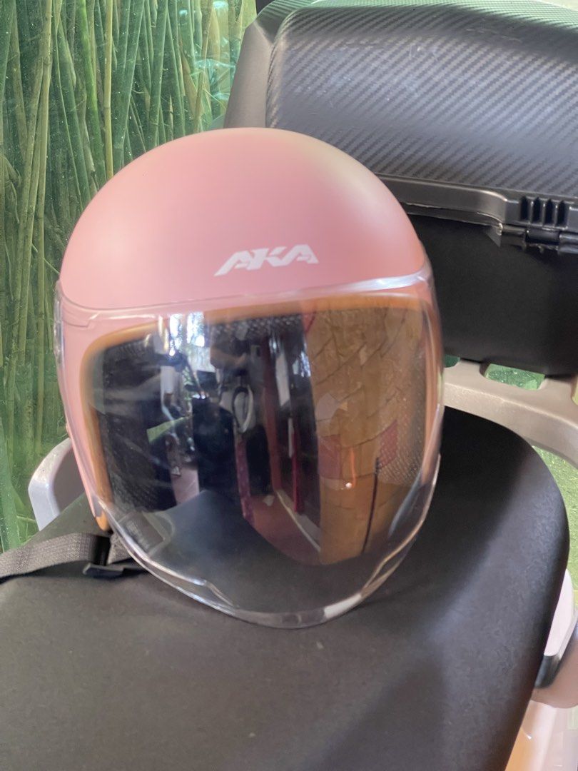 AKA Pink Motorcycle Half-Helmet with Clear Visor (Category: Bicycles) located in San Pablo. Submitted by vrmthrsainz (Listing ID 1467421395, Image 1). Description: - Brand: AKA Motorcycle Helmet - Color: Matte pink finish with stylish brown trim - Visor: Clear, moves up and down smoothly - Interior: Comfortable black padding - Safety: Certified product safety sticker on the back - Closure: Adjustable chin strap with quick-release buckle.