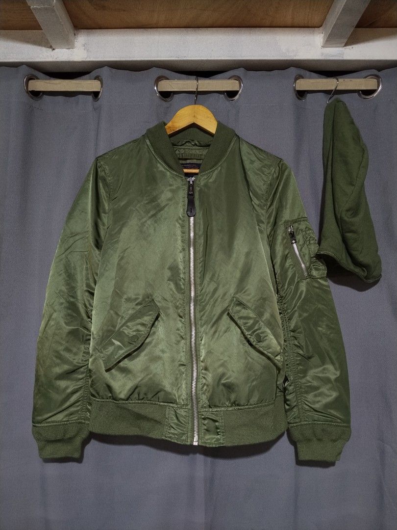 Alpha Industries MA-1 Bomber Jacket with Hood (Category: Coats, Jackets and Outerwear) located in Pasig City. Submitted by loveforlux_2025 (Listing ID 1467411955, Image 2). Description: - Brand: Alpha Industries - Color: Sage Green with classic orange lining - Features: Detachable matching hood with back logo embroidery - Details: Iconic sleeve utility pocket with red 'Remove Before Flight' style tag - Hardware: Heavy-duty branded metal zippers -