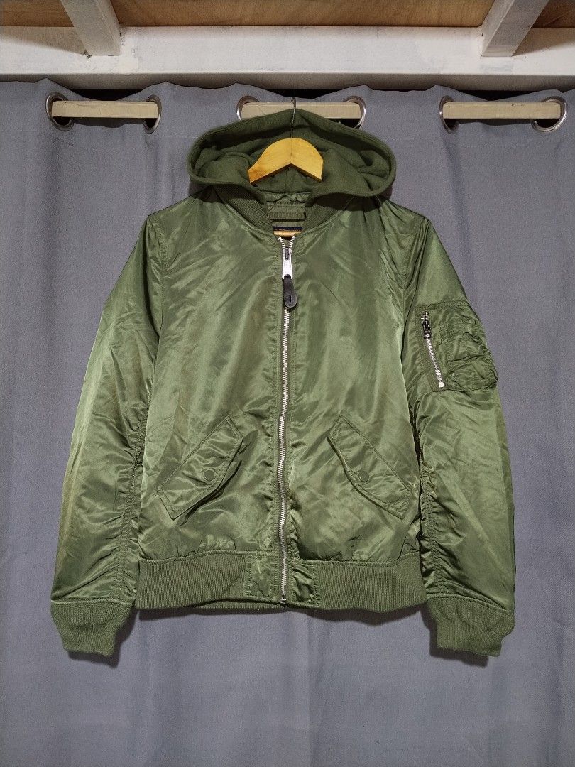 Alpha Industries MA-1 Bomber Jacket with Hood (Category: Coats, Jackets and Outerwear) located in Pasig City. Submitted by loveforlux_2025 (Listing ID 1467411955, Image 1). Description: - Brand: Alpha Industries - Color: Sage Green with classic orange lining - Features: Detachable matching hood with back logo embroidery - Details: Iconic sleeve utility pocket with red 'Remove Before Flight' style tag - Hardware: Heavy-duty branded metal zippers -