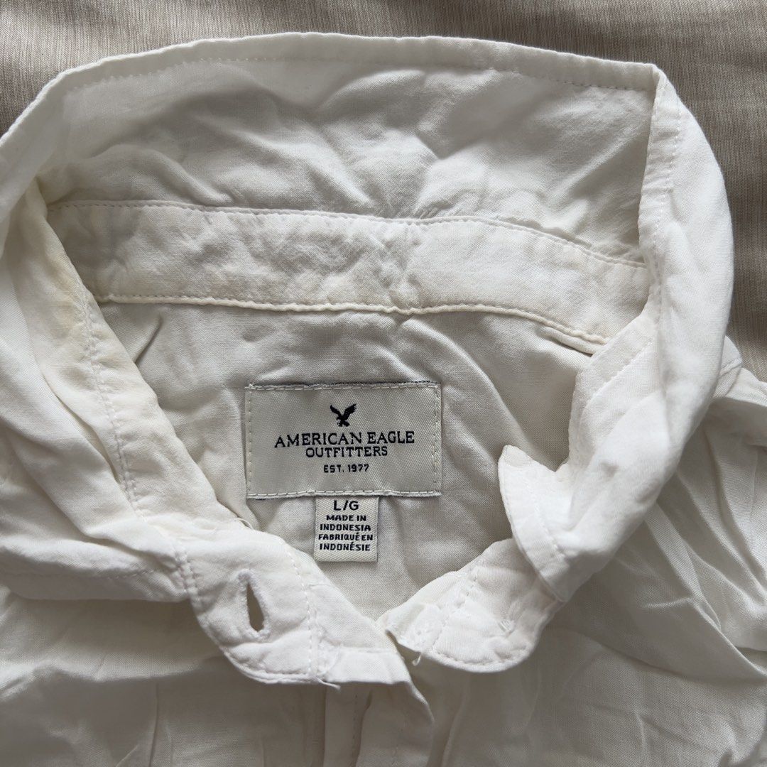 American Eagle Outfitters White Sleeveless Button-Down Tank Top (Category: Sleeveless) located in Pasig City. Submitted by jenscloset86 (Listing ID 1467395781, Image 3). Description: Brand: American Eagle Outfitters Size: Large • Slightly used in the beach • Yellow stain in the neck area due to sunblock lotion. • Wrinkled due to storage. Measurement (in inches): Length: 22” Bust: 40”.