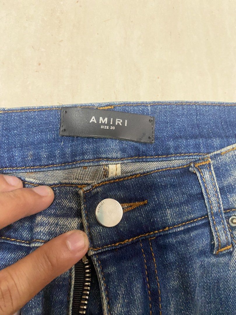 AMIRI Distressed Slim Jeans Size 30 (Category: Jeans) located in Alburquerque. Submitted by zanegavynn43872 (Listing ID 1467363978, Image 2). Description: - Brand: AMIRI - Style: Distressed denim jeans with blue wash - Size: 30 - Details: Distressed knees with ribbed underlays and signature Riri hardware on the fly - Material: 98% cotton, 2% elastane (Made in USA with Italian materials) - Condition: Excellent, with clean interior tags and waist b