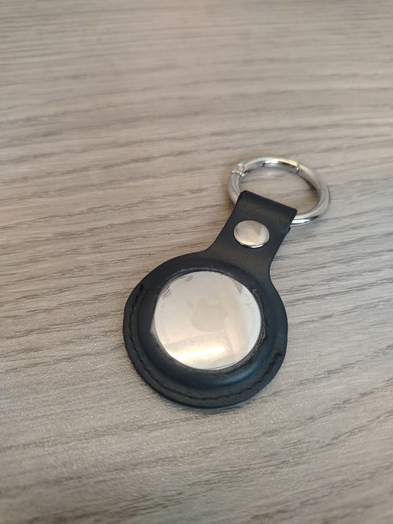 Apple AirTag with Black Leather Keychain Holder (Category: Cases & Sleeves) located in Manila. Submitted by dmab3005 (Listing ID 1467398745, Image 3). Description: - Authentic Apple AirTag tracker - Includes a black leather keychain case with a secure snap button and metal ring - Silver stainless steel backing with standard Apple logo - White plastic face features minor smudging from everyday use - 100% fully functional and ready to pair with iOS