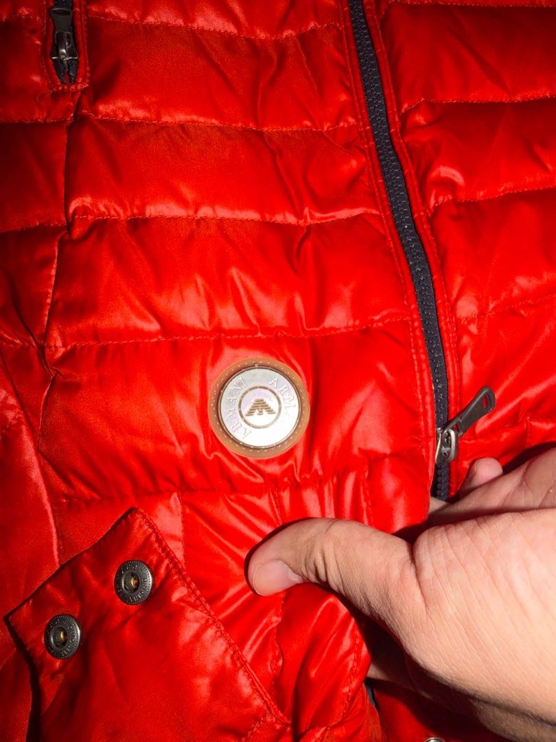 Armani Junior Red Puffer Jacket Size 4A (Category: Coats, Jackets and Outerwear) located in Davao. Submitted by sadthrift (Listing ID 1467514526, Image 3). Description: - Brand: Armani Junior - Item: Winter Puffer Jacket - Color: Bright Red - Size: 4A (fits approx. 106cm) - Material: 100% Polyester (shell and lining) - Features: Attached hood with snap buttons, front zip closure, two zippered side pockets, round logo badge on chest - Condition: C