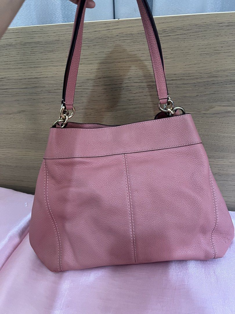 Coach Pink Leather Shoulder Bag (Category: Luxury Bags & Wallets) located in San Jose del Monte. Submitted by joy_ochoa (Listing ID 1467424514, Image 2). Description: - Brand: Coach - Color: Dusty pink with gold-tone hardware - Material: Pebbled leather finish - Closure: Secure zip top - Straps: Dual shoulder straps - Interior: Cute white floral lining with a zippered pocket and slip pockets - Size: Medium, fits daily essentials easily - Conditio
