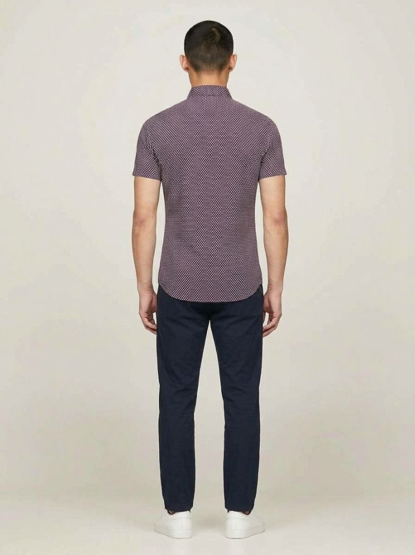 Authentic Tommy Hilfiger Men's Burgundy Patterned Short Sleeve Button down (Category: Tshirts & Polo Shirts ) located in Quezon City. Submitted by SustainableFashionatbp (Listing ID 1467492935, Image 2). Description: - Brand: Tommy Hilfiger - Color: Burgundy with a small geometric dot pattern - Style: Short sleeve, button-down front with a standard collar - Versatility: Easy to style for both casual days and smart-casual office wear - Fit: True t