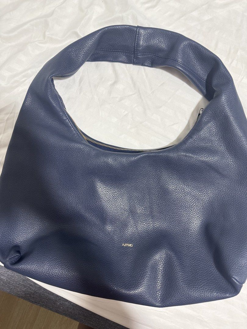 Aztrid Hobo Bag (Category: Shoulder Bags) located in Rizal. Submitted by faven419 (Listing ID 1467482271, Image 1). Description: - Color: Deep blue - Material: Textured faux leather - Style: Slouchy hobo with curved handle - Closure: Secure top zipper - Branding: Small metallic ASTRID logo - Interior: Spacious, easily fits phone, wallet, and keys - Design: Soft structure that folds naturally.
