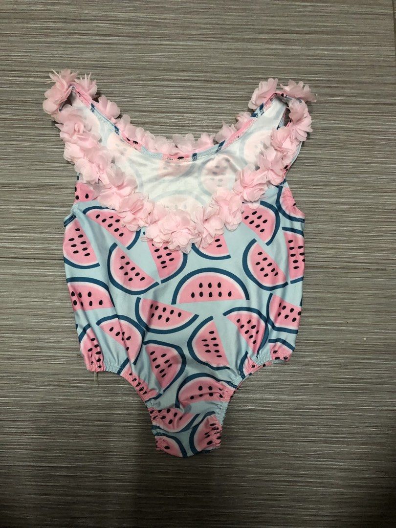 Watermelon Swimsuit (Category: Babies & Kids Fashion) located in Cavite. Submitted by ai__chang (Listing ID 1467406292, Image 2). Description: - Adorable watermelon slice print on a light blue base - Cute pink sheer ruffled chiffon floral trim along the neckline and straps - Comfortable, stretchy one-piece design with a scoop neckline and sleeveless cut - Ideal for pool days, beach trips, and summer fun.