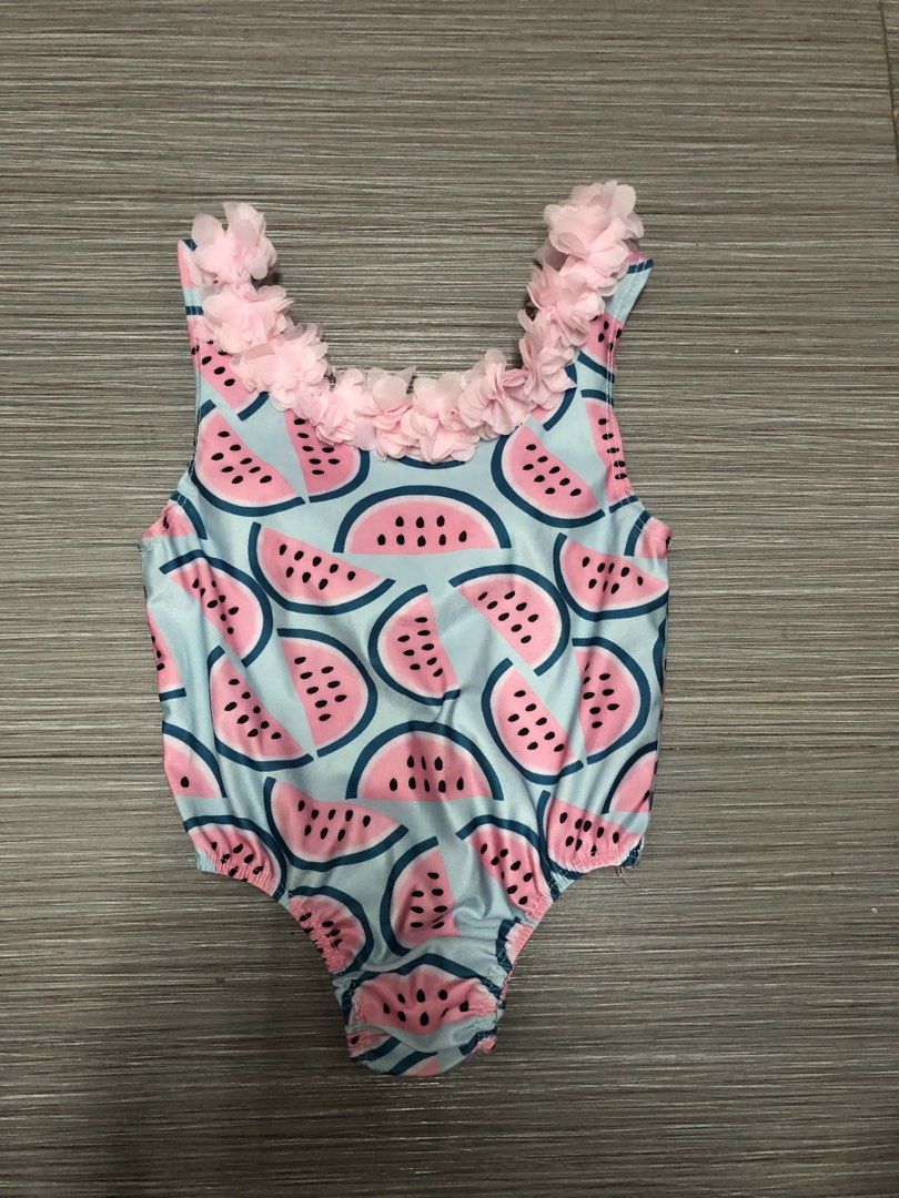 Watermelon Swimsuit (Category: Babies & Kids Fashion) located in Cavite. Submitted by ai__chang (Listing ID 1467406292, Image 1). Description: - Adorable watermelon slice print on a light blue base - Cute pink sheer ruffled chiffon floral trim along the neckline and straps - Comfortable, stretchy one-piece design with a scoop neckline and sleeveless cut - Ideal for pool days, beach trips, and summer fun.