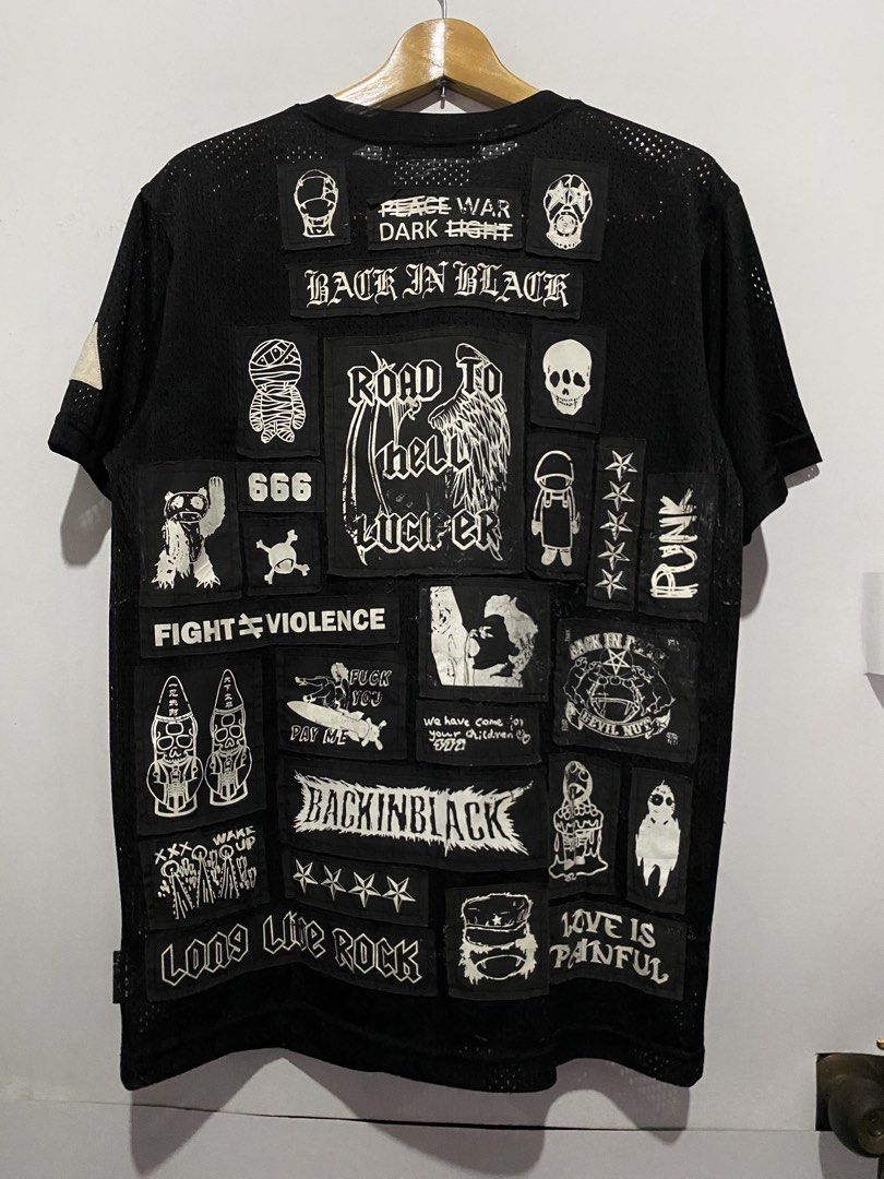 Back in Black Patchwork Mesh T-Shirt (Category: Shirts) located in Jaen. Submitted by oshimamark58418 (Listing ID 1467552179, Image 2). Description: Black mesh t-shirt covered in white screenprinted patches front and back. Brand tag reads Back in Black by Devil Nut Under The Flag. Tagged size L, measures 21 by 29 inches. Crew neck, short sleeves. Heavy punk, grunge aesthetic with graphics like skulls, text, and cartoons all over..