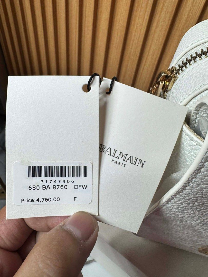 Balmain White Leather B-Box Shoulder Bag (Category: Luxury Bags & Wallets) located in Manila. Submitted by iamangelica20 (Listing ID 1467452776, Image 3). Description: - Brand: Balmain - Color/Material: White pebbled leather - Hardware: Gold-tone with large B logo and bold Balmain lettering - Closure: Zip top - Condition: Brand new / Never used (protective plastic still on hardware) - Inclusions: Original box, dust bag, and store tags.