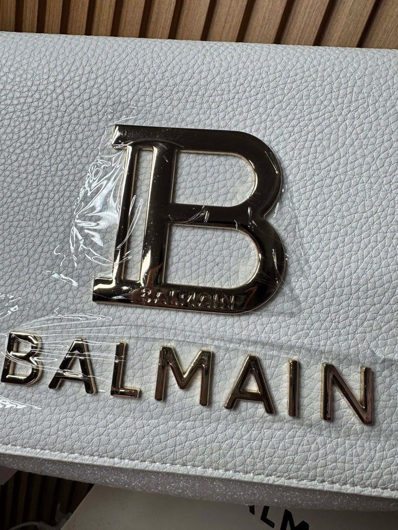 Balmain White Leather B-Box Shoulder Bag (Category: Luxury Bags & Wallets) located in Manila. Submitted by iamangelica20 (Listing ID 1467452776, Image 2). Description: - Brand: Balmain - Color/Material: White pebbled leather - Hardware: Gold-tone with large B logo and bold Balmain lettering - Closure: Zip top - Condition: Brand new / Never used (protective plastic still on hardware) - Inclusions: Original box, dust bag, and store tags.