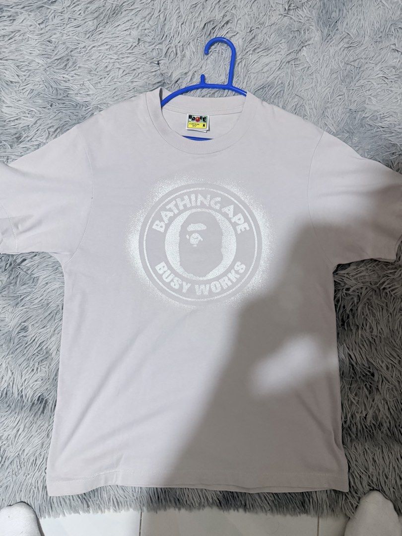 BAPE Bathing Ape Busy Works Tee Gray Size M (Category: Tshirts & Polo Shirts ) located in Manila. Submitted by m1ggo (Listing ID 1467527007, Image 1). Description: - Brand: BAPE (A Bathing Ape) - Item: Busy Works Graphic T-Shirt - Color: Grey - Size: Medium - Material: 100% Cotton - Condition/Details: Classic crewneck, short sleeves, inner tags intact with gold ape head sticker - Style: Comfortable streetwear staple, perfect for everyday wear.