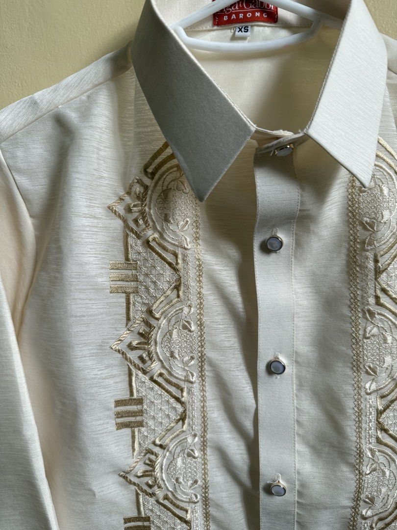 Barong Tagalog (XS) (Category: Formal Shirts) located in Manila. Submitted by double__j (Listing ID 1466982577, Image 3). Description: - Brand: Aga't Gabbi - Color: Ivory cream with intricate tan embroidery - Design: Long sleeves, standard button-up closure, pointed collar - Occasion: Ideal for weddings, cultural events, and formal gatherings - Sizing: XS.