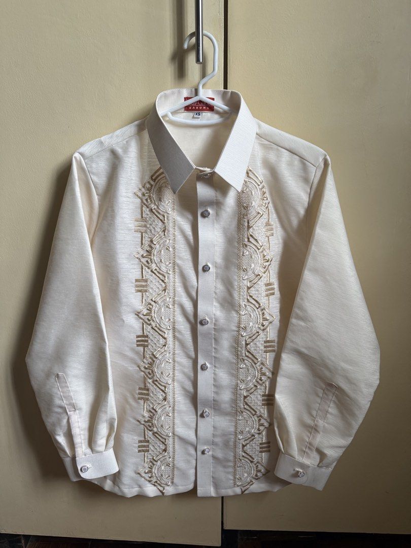 Barong Tagalog (XS) (Category: Formal Shirts) located in Manila. Submitted by double__j (Listing ID 1466982577, Image 2). Description: - Brand: Aga't Gabbi - Color: Ivory cream with intricate tan embroidery - Design: Long sleeves, standard button-up closure, pointed collar - Occasion: Ideal for weddings, cultural events, and formal gatherings - Sizing: XS.