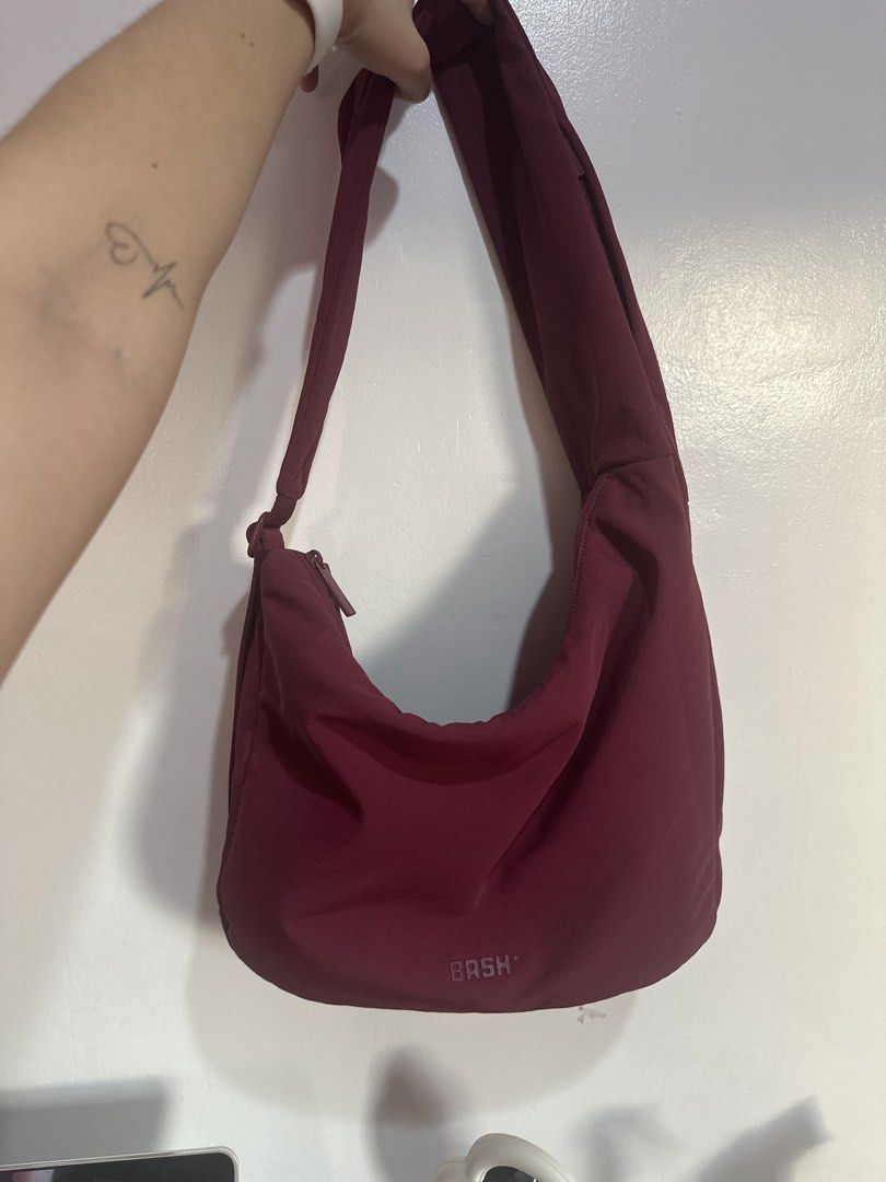 BASH Jet Set On-The-Go Bag (Category: Shoulder Bags) located in Cainta. Submitted by xyzasisa (Listing ID 1467454549, Image 1). Description: - Brand: Bash - Color: Deep maroon / burgundy - Material: Durable and soft nylon - Design: Slouchy everyday shape with a thick shoulder strap - Storage: Secure zippered main compartment plus exterior zipper pockets on the side and back - Details: Custom branded zipper pulls - Used only when I toured Bangkok 