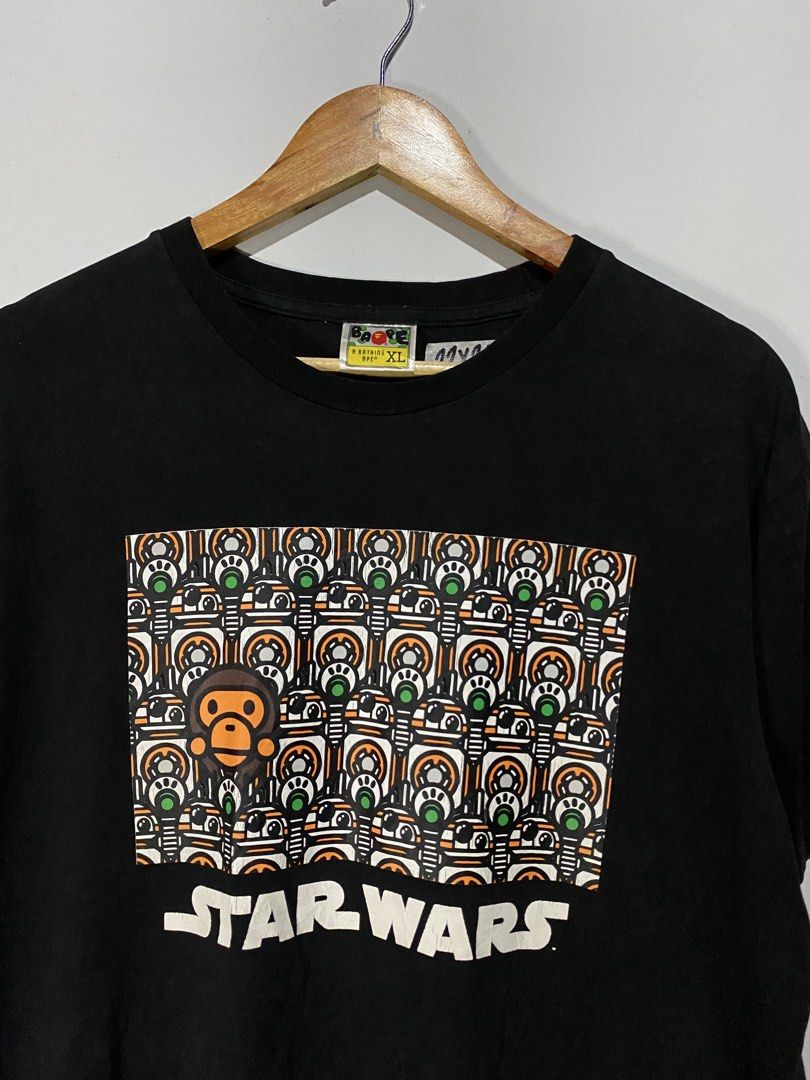 BATHING APE STARWARS TSHIRT (Category: Tshirts & Polo Shirts ) located in Jaen. Submitted by oshimamark58418 (Listing ID 1467538130, Image 3). Description: - Brand: A Bathing Ape (BAPE) x Star Wars - Color: Black - Size: Tagged XL, but measures approx. 22" x 26" (fits like Men's Medium) - Design: Unique front graphic featuring Star Wars droids and BAPE head, plus Star Wars branding on the back collar - Details: Signature BAPE sleeve tag included 