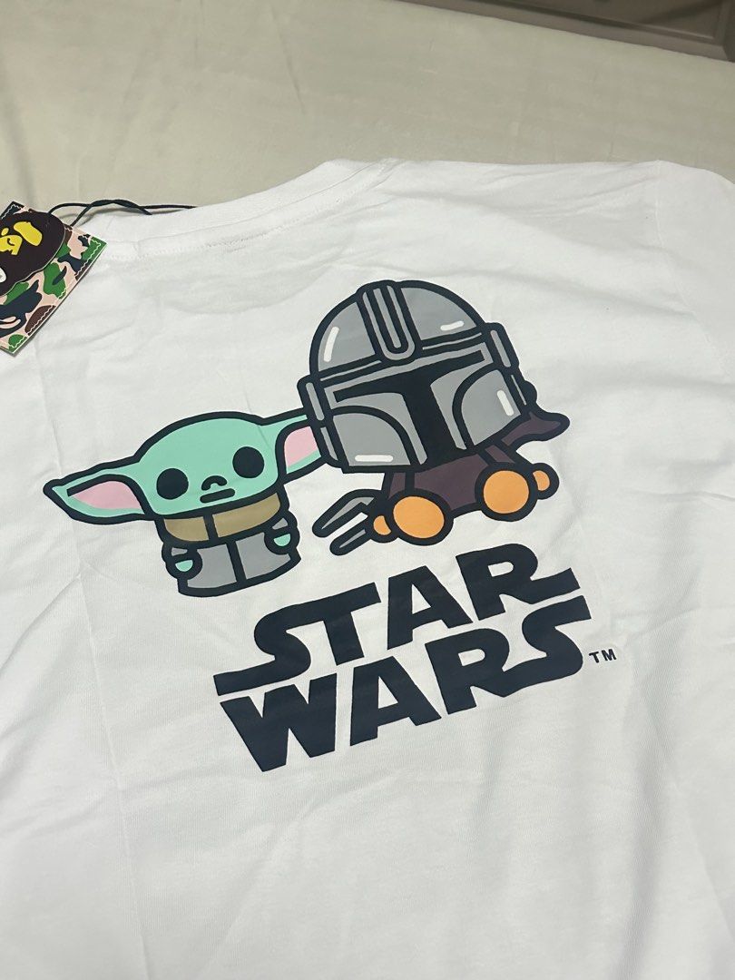 Bathing Ape x Star Wars Graphic Tee White Size L (Category: Tshirts & Polo Shirts ) located in Manila. Submitted by jmdrgooddeals (Listing ID 1467378681, Image 2). Description: - Brand: Bathing Ape x Star Wars Collaboration - Condition: Brand new with original store tags attached - Size: L (label inside collar) - Color: Clean white - Front Design: Stormtrooper, Kylo Ren, and Baby Milo graphic - Back Design: Grogu, The Mandalorian, and Star Wars l