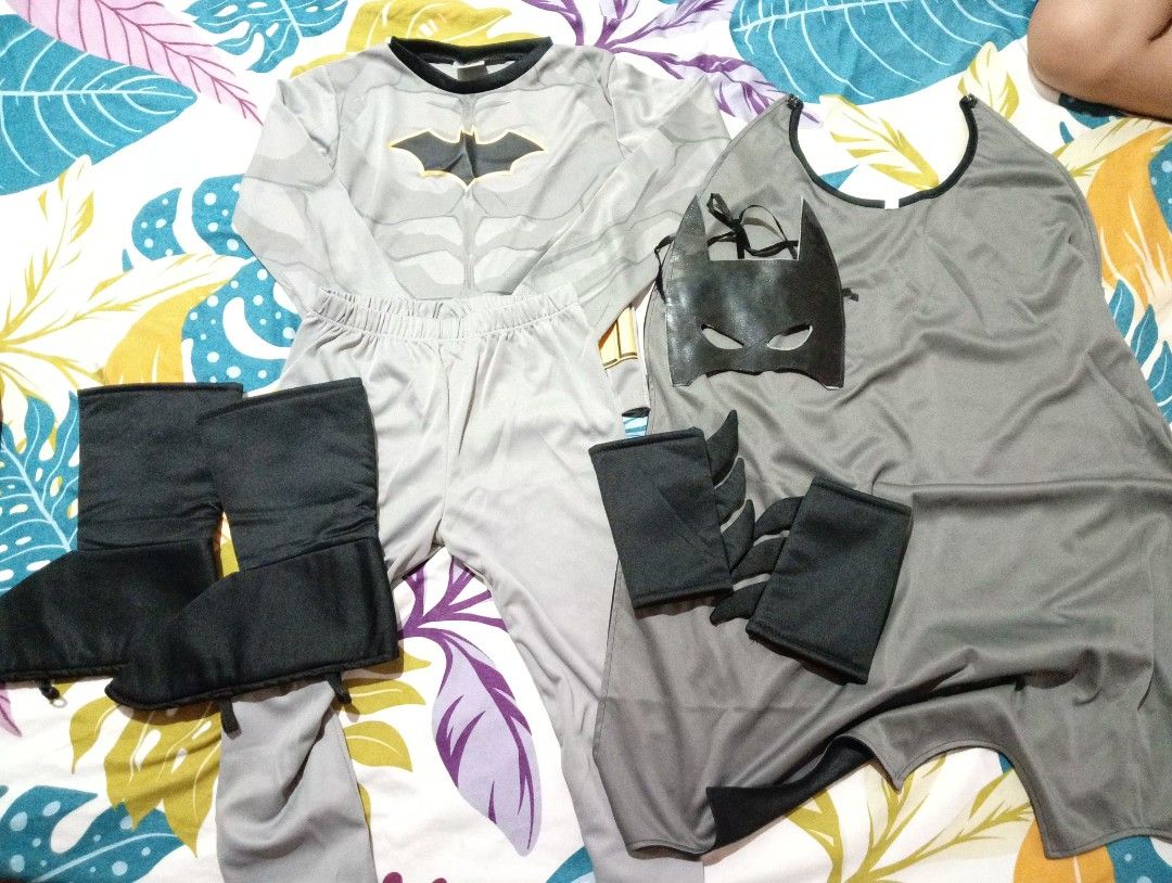 Batman Costume Set Size M (Category: Babies & Kids Fashion) located in Caloocan City. Submitted by mimieyahs_japanonlineshop (Listing ID 1467486151, Image 1). Description: - Official DC merchandise (2020) - Size: Medium (tag on collar) ages 4-5yrs old - Includes grey top and pants with printed chest logo - Accessories: Grey cape, black mask, boot covers, and gauntlets - Great for parties, Halloween, and dress-up events flaws on mask: nasira yung 