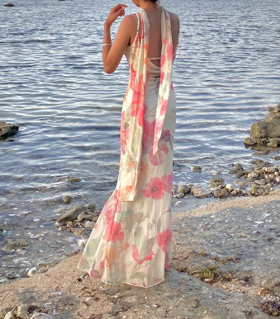 Beach Maxi Dress with Matching Scarf (Category: Dresses) located in Taguig. Submitted by seo_ari (Listing ID 1467378197, Image 2). Description: - Long floral maxi dress with vibrant pink, orange, and green flowers on a soft cream background - Chic cowl neckline with adjustable thin spaghetti straps - Trendy open-back design with hanging ties - Lightweight, floor-length fabric for effortless movement - Includes a matching free neck scarf to comple