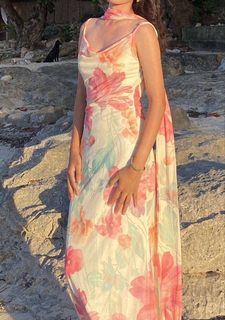 Beach Maxi Dress with Matching Scarf (Category: Dresses) located in Taguig. Submitted by seo_ari (Listing ID 1467378197, Image 3). Description: - Long floral maxi dress with vibrant pink, orange, and green flowers on a soft cream background - Chic cowl neckline with adjustable thin spaghetti straps - Trendy open-back design with hanging ties - Lightweight, floor-length fabric for effortless movement - Includes a matching free neck scarf to comple