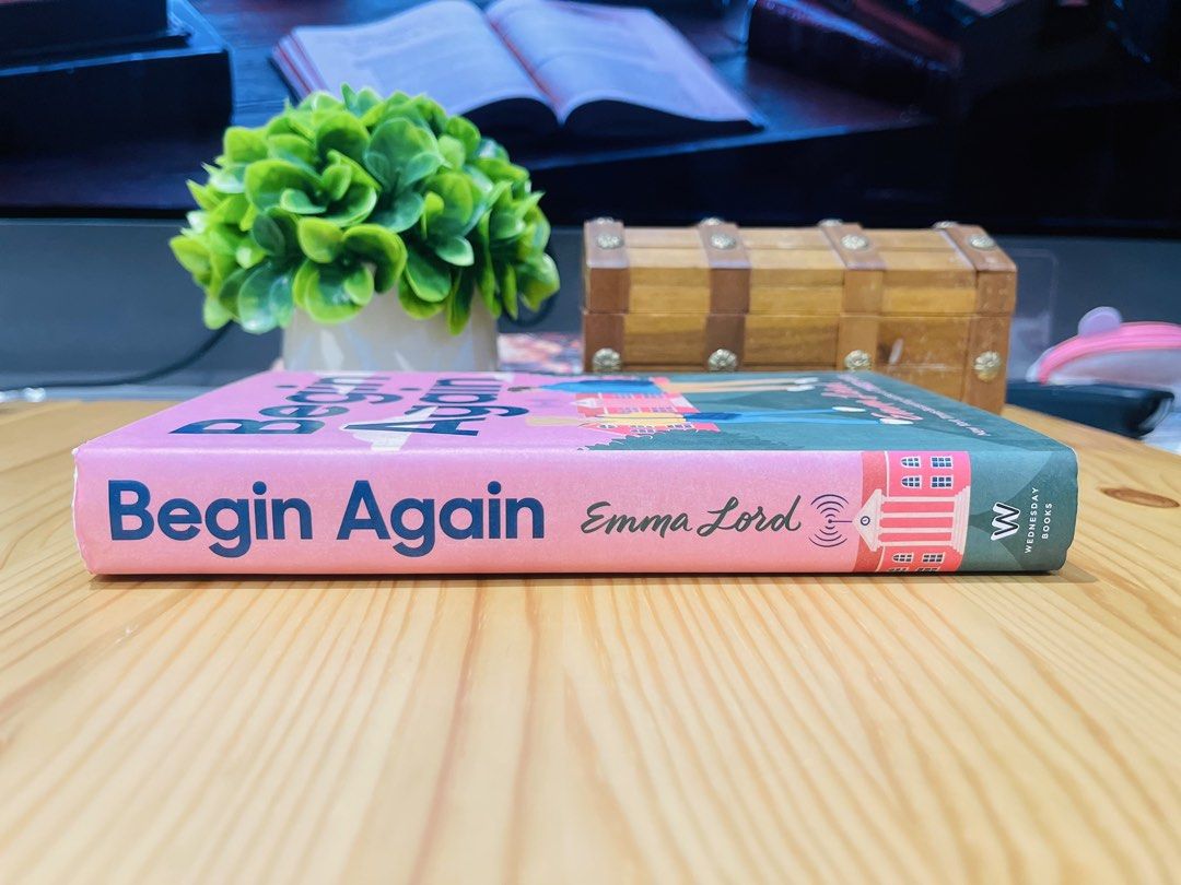 Begin Again by Emma Lord (Category: Storybooks) located in Makati City. Submitted by pagesandplay (Listing ID 1467551753, Image 3). Description: - Title: Begin Again - Author: Emma Lord - Publisher: Wednesday Books - Format: Hardcover - Cover Art: Pink and blue illustrated design featuring two characters - Condition: Clean white pages with minimal shelf wear on the edges - Genre: Young Adult (YA) contemporary romance.