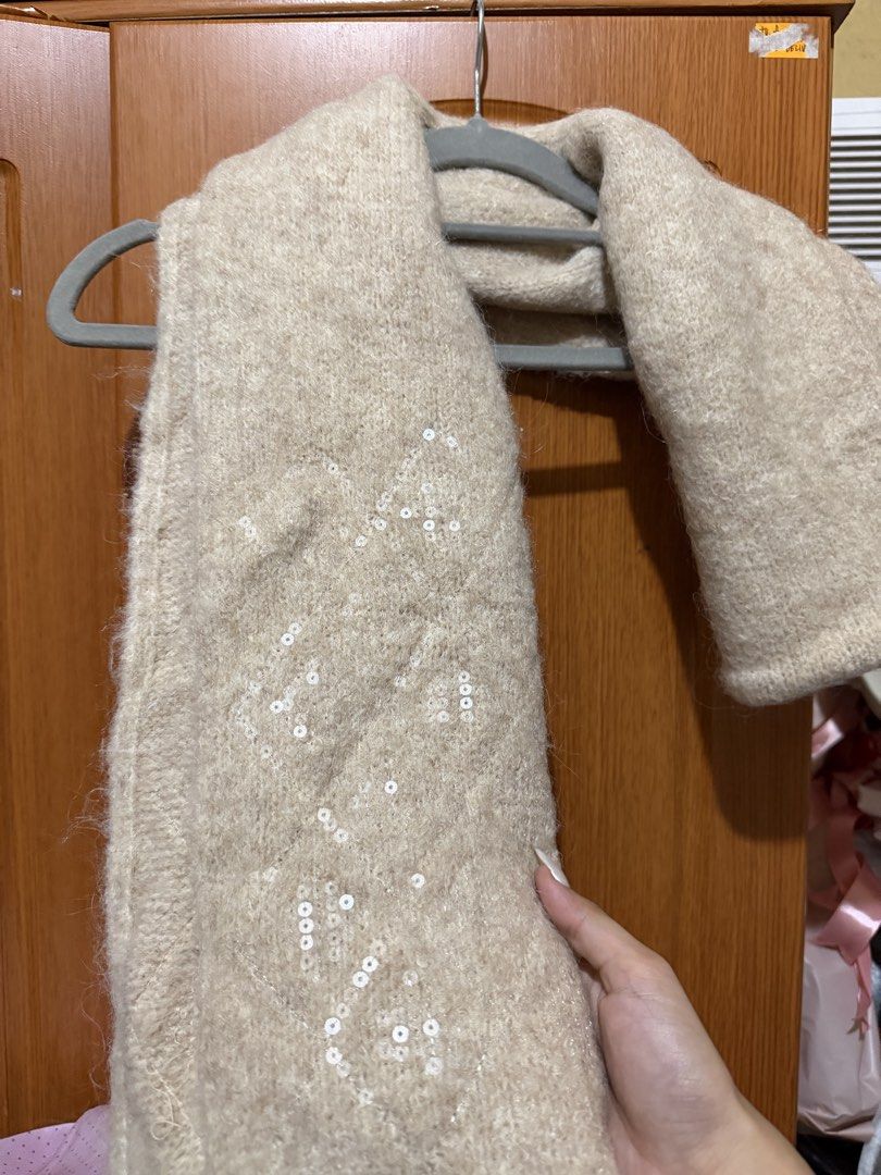Beige Knitted Scarf with Sequin Details (Category: Scarves) located in Muntinlupa City. Submitted by biancaagbscloset (Listing ID 1467536690, Image 1). Description: - Color: Versatile neutral beige - Material: Soft, warm wool texture - Detail: Delicate sequin embroidery along the length - Style: Fluffy knit that hangs nicely over coats and sweaters - Condition: Brand new / Excellent (ready to wear for winter).