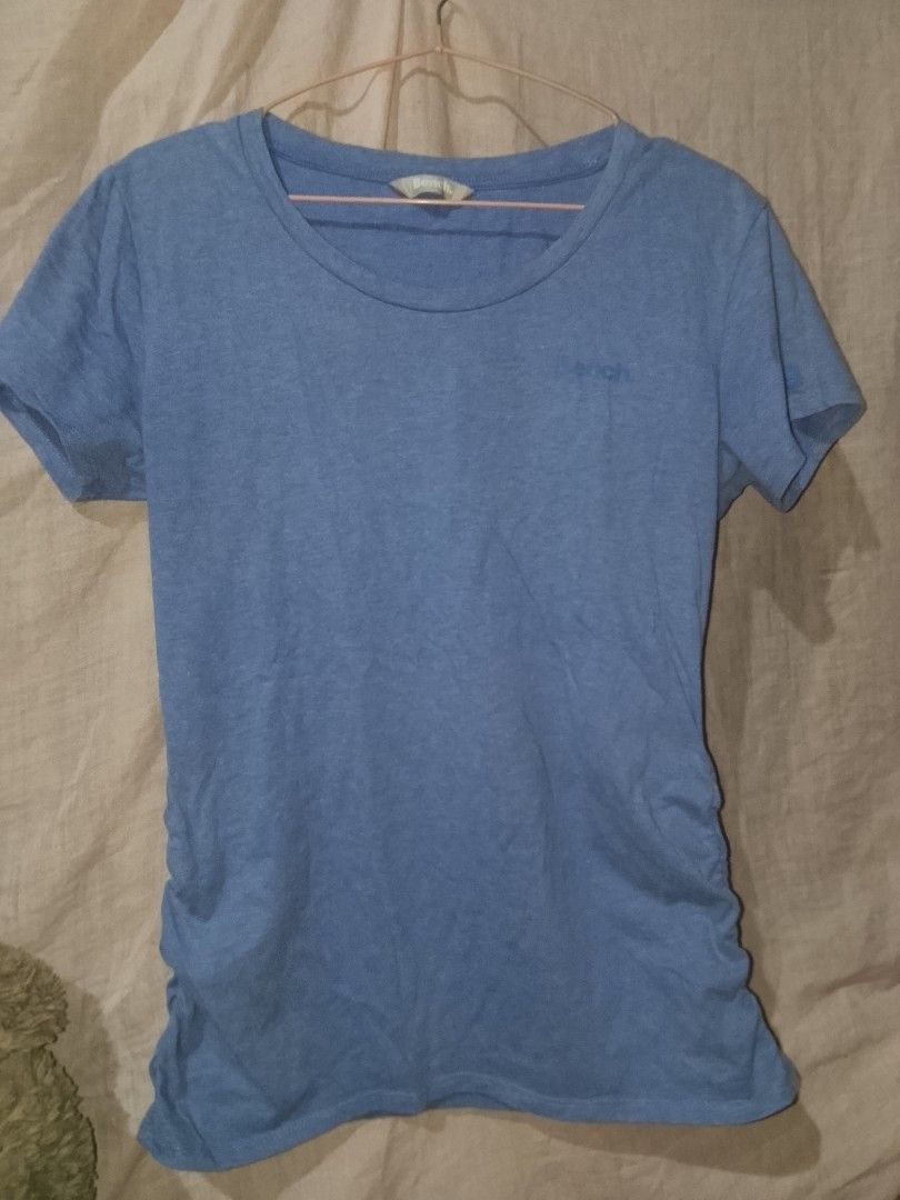 Bench light blue tee (Category: Blouses) located in Adams. Submitted by yelri555 (Listing ID 1467495928, Image 1). Description: Bench. Light Blue Tee - L ₱149 Details: - Brand: Bench. (Authentic / Legit) - Size: L on tag, fits S-L - Color: Light blue / Powder blue - Condition: 8.5/10 - has light stain (see photo), needs wash - Print: Bench. small logo -has side seam fit Note: Has minor washable stains on front.