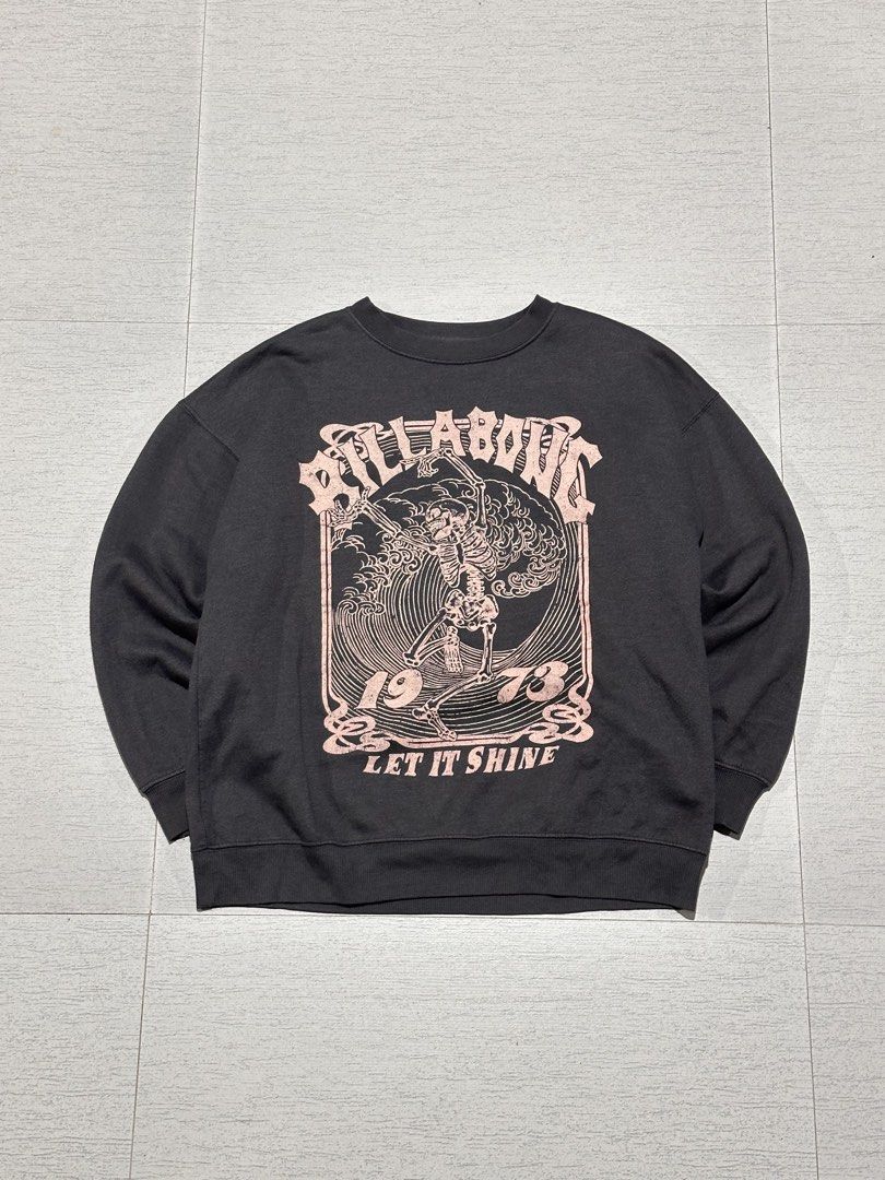 Billabong Let It Shine Skeleton Graphic Sweatshirt (Category: Coats, Jackets and Outerwear) located in La Trinidad. Submitted by christian_dutch (Listing ID 1467562667, Image 1). Description: - Brand: Billabong - Color: Dark grey with faded pink lettering - Size: Large (Standard fit) - Design: Large skeleton graphic on front with '1973' and 'Let It Shine' - Interior: Soft fleece lining for extra warmth and comfort - Details: Ribbed cuffs and hem 