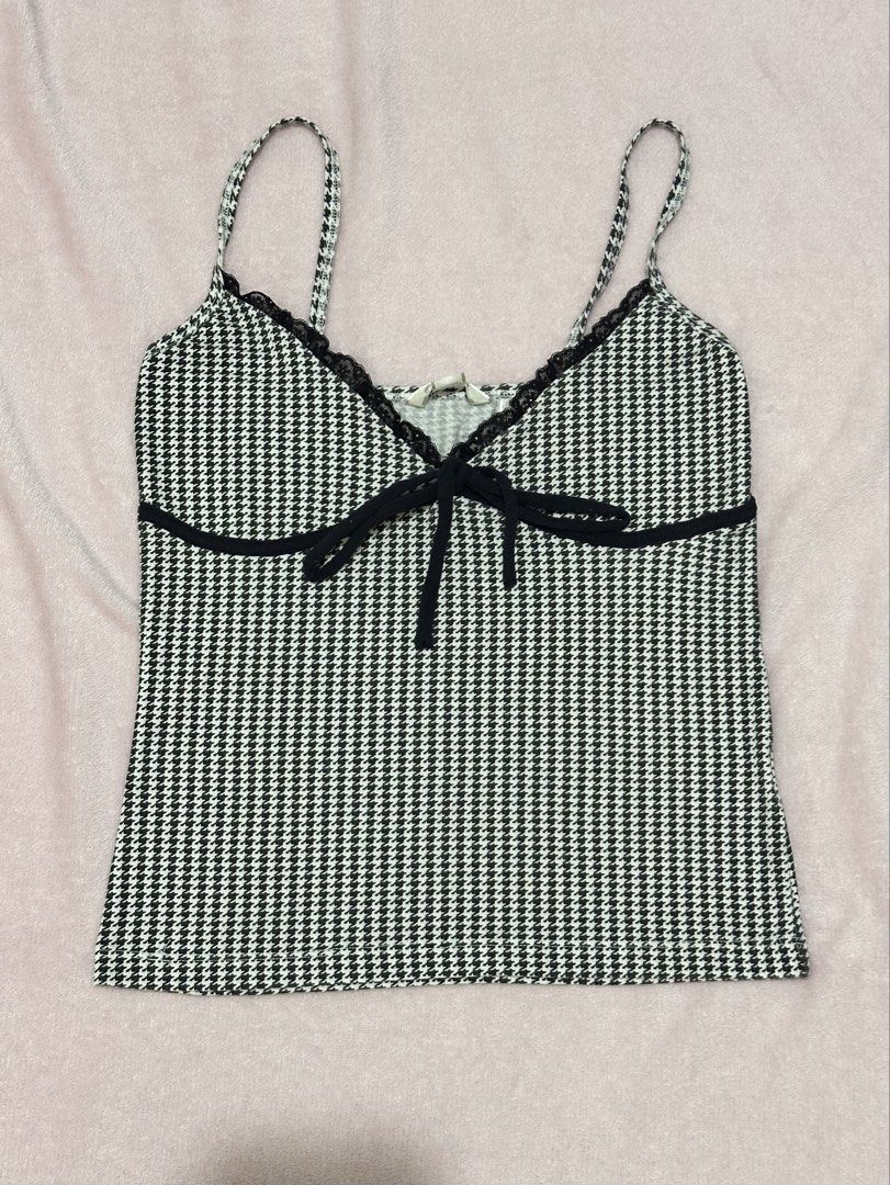 Black and White Houndstooth Cami Tank Top with Bow (Category: Sleeveless) located in Santa Rosa. Submitted by phbrnf (Listing ID 1467540332, Image 1). Description: - Style: Black and white houndstooth cami - Details: V-neckline with black lace trim and a cute small black bow - Straps: Adjustable thin straps - Fit & Fabric: Soft, stretchy, and comfortable - Versatility: Great for casual days out or layering under jackets.