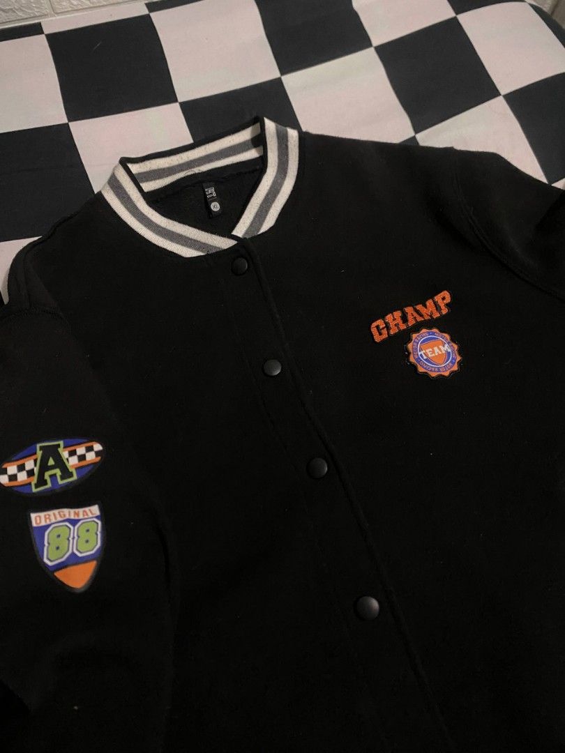 Black Champ Varsity Jacket (Category: Coats, Jackets and Outerwear) located in Binan City. Submitted by kaiz3nnnn_ (Listing ID 1467488142, Image 2). Description: - Color: Black - Embroidery: 'CHAMP' and team patch on the chest - Excellent condition - Mode of Payment: Gcash.
