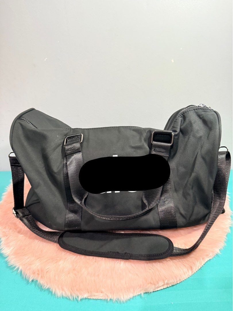 Black Duffle Bag Gym Bag (Category: Sling Bags) located in Quezon City. Submitted by shaberbree (Listing ID 1467521646, Image 1). Description: - Color: Black with prominent white logo print - Material: Durable high-quality nylon - Compartments: Wide dual-zipper main opening, side zipper compartment, and internal zip pocket - Interior: Branded "alo yoga" patterned fabric lining - Straps: Sturdy grab handles + removable/adjustable shoulder strap wi