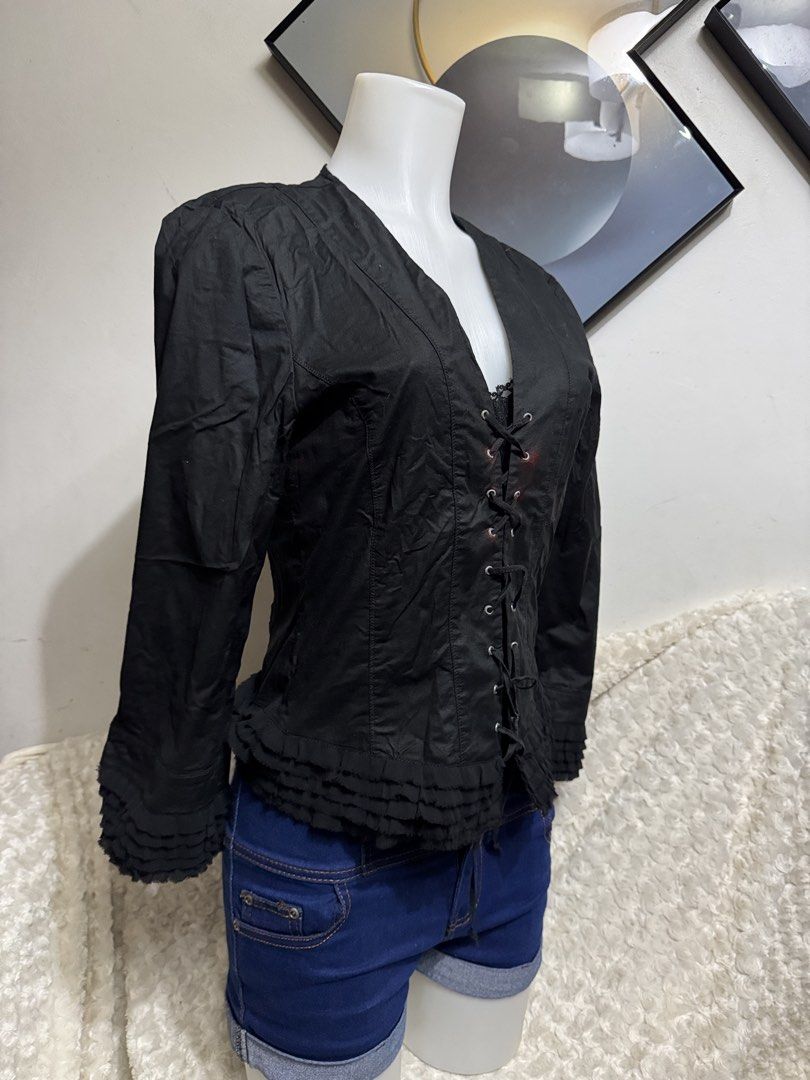 Black laced front blouse with ruffled hem (Category: Blouses) located in Marikina City. Submitted by lorradel (Listing ID 1467510509, Image 2). Description: - fits M- L - Color: Black with red staining accents around eyelets - Style: Gothic, alternative long-sleeve blouse - Details: Front lace-up closure with metal eyelets, V-neckline - Cuffs & Hem: Flared cuffs and ruffled hem - Back: Vertical seam detailing - MAY HAVE some washable stains (hind