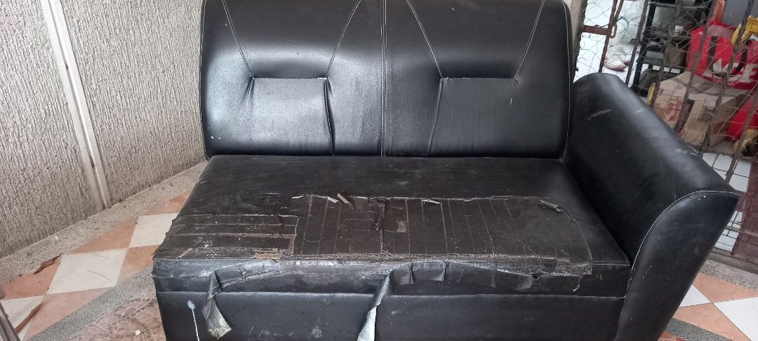Black leatherette 2-seater sofa with armrest (Category: Sofas) located in Quezon City. Submitted by ki_cai (Listing ID 1467440083, Image 1). Description: - Type: 2-seater faux leather sofa with right-side armrest - Color: Classic black - Condition: Significant wear, tears, and tape repairs on the seat cushion - Best for: Reupholstering, recycling projects, or casual garage/workshop seating area: batasan hills q.c. .