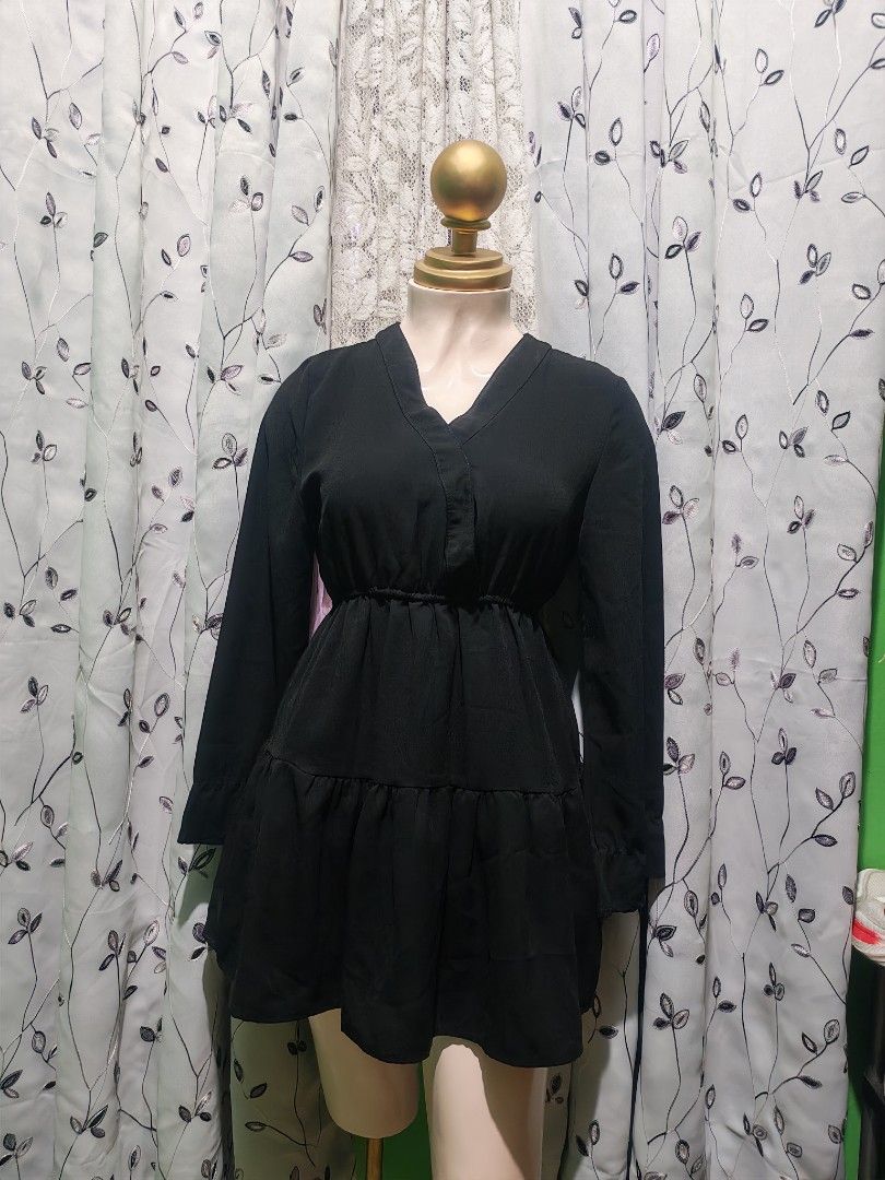 Black Long Sleeve Mini Dress (Category: Dresses) located in Caloocan City. Submitted by _misskaye (Listing ID 1467472781, Image 1). Description: - Color: Classic Black - Style: Long sleeve mini dress with V-neckline and folded collar detail - Fit: Elastic waistband for a comfortable, fitted silhouette - Design: Layered ruffled skirt portion for a chic look - Fabric: Smooth material throughout - Versatility: Easy to dress up with heels or style ca