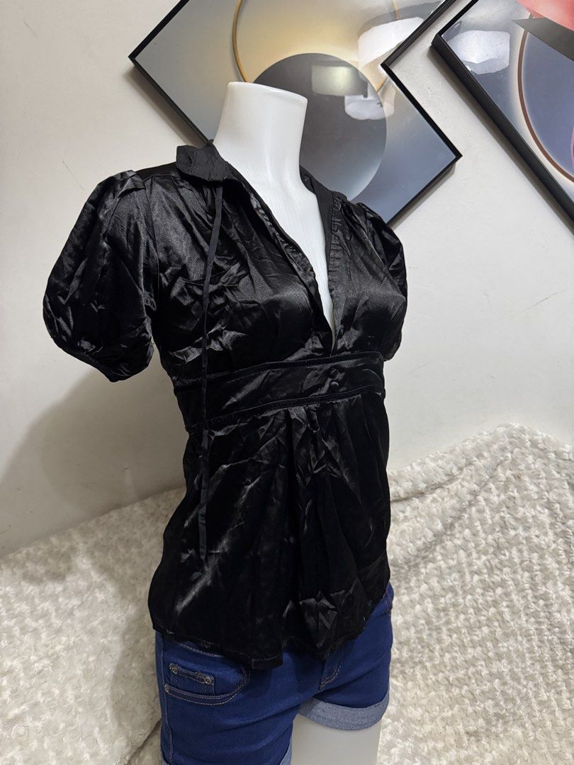 Black satin puff sleeve v-neck blouse (Category: Blouses) located in Marikina City. Submitted by lorradel (Listing ID 1467514924, Image 2). Description: - Color: Black - Material: Soft, lightweight, and shiny satin fabric - Design: Deep V-neck collar with short puff sleeves - Fit: Empire waist with gathered pleats below the bust and two front button accents - Styling: Perfect for dressing up with jeans or a skirt - MAY HAVE some washable stains (