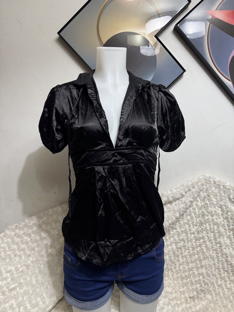 Black satin puff sleeve v-neck blouse (Category: Blouses) located in Marikina City. Submitted by lorradel (Listing ID 1467514924, Image 1). Description: - Color: Black - Material: Soft, lightweight, and shiny satin fabric - Design: Deep V-neck collar with short puff sleeves - Fit: Empire waist with gathered pleats below the bust and two front button accents - Styling: Perfect for dressing up with jeans or a skirt - MAY HAVE some washable stains (