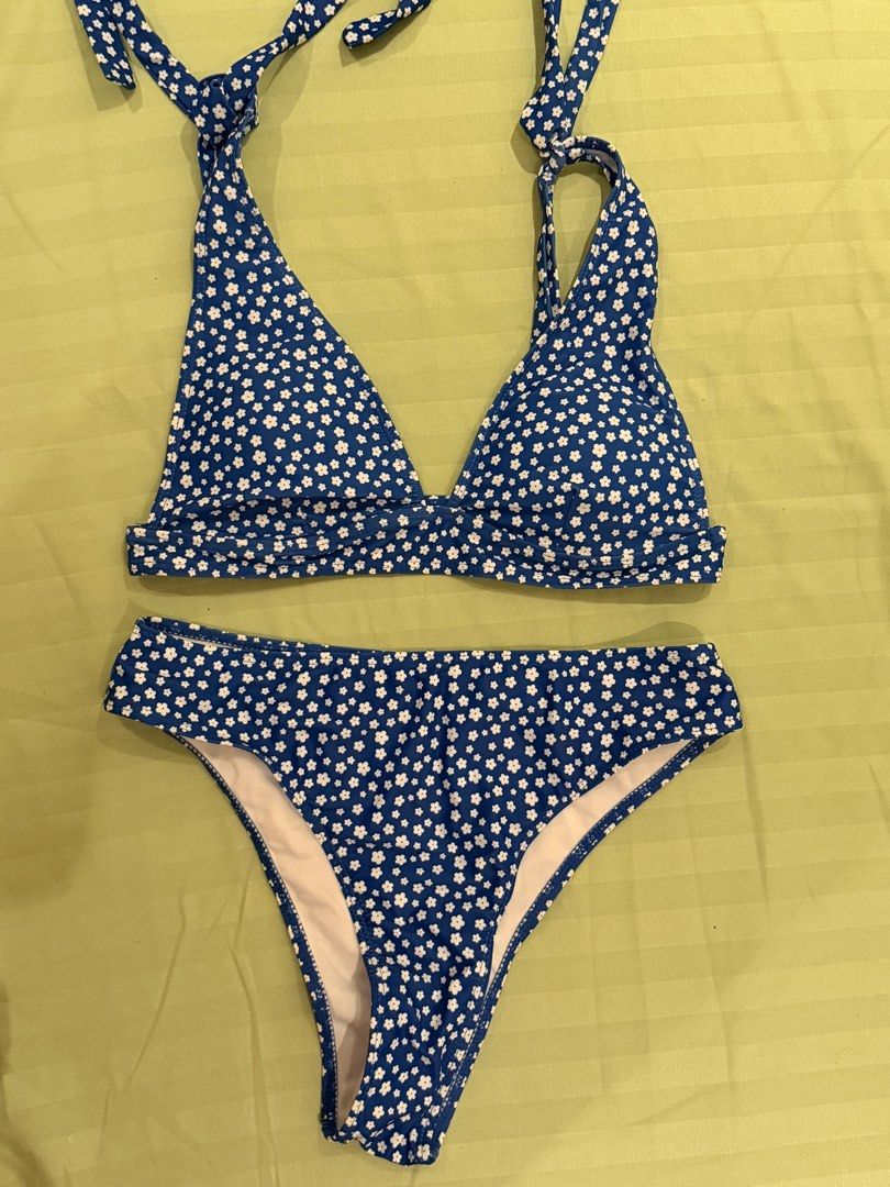 Blue and White Floral Print Two-Piece Bikini Set (Category: Bikinis & Swimsuits) located in Quezon City. Submitted by caathhx_ (Listing ID 1467509549, Image 1). Description: - Blue two-piece swimsuit with an all-over tiny white flower pattern - Halter neck top with adjustable ties at the back and neck - High-waisted bottoms featuring a clean white inner lining - Stretchy, comfortable fabric ideal for swimming and lounging - Trendy and flattering 