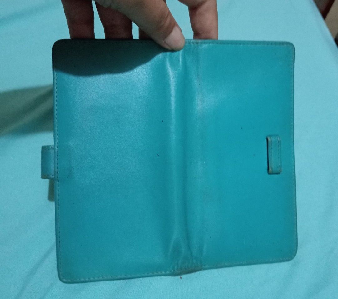 Blue leather wallet with multiple card slots (Category: Wallets & Card holders) located in Makati City. Submitted by YSL80022 (Listing ID 1467285415, Image 3). Description: - Color: Teal blue - Material: Genuine Leather - Features: Multiple 14 card slots, main cash compartment, and side strap with snap button closure - Condition: Pre-loved with some visible wear and tear on the inner lining and cardholder fabric - Status: Cleaned out from closet,
