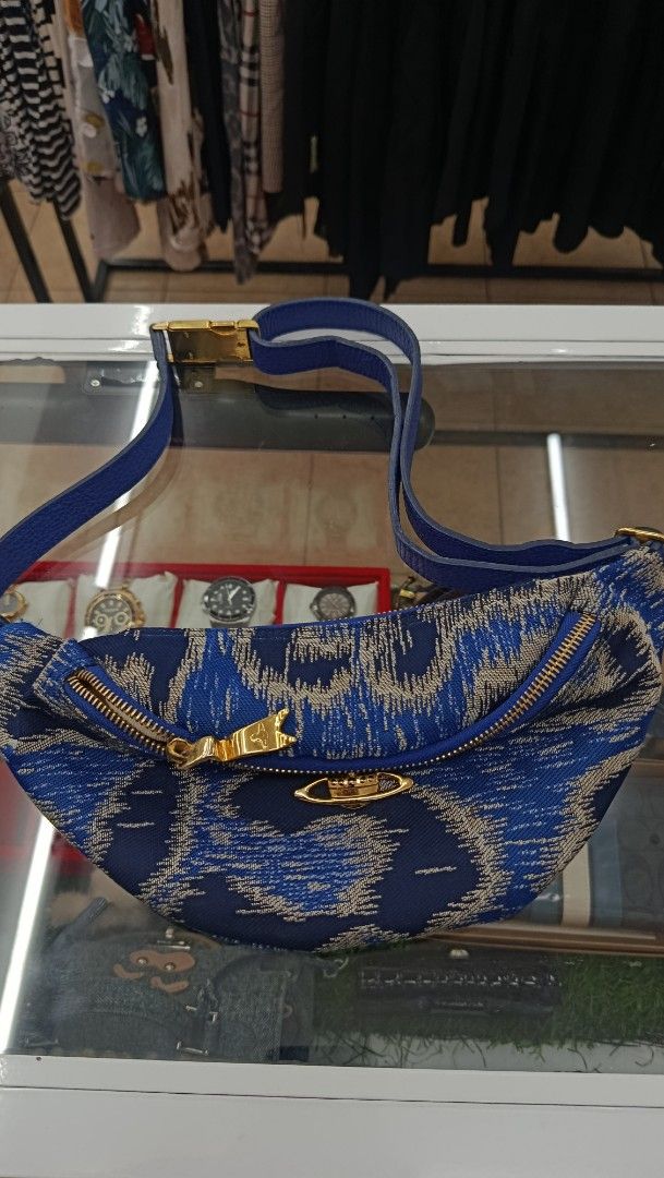 Blue Patterned Crossbody Bag with Gold Hardware (Category: Cross-body Bags) located in Aritao. Submitted by steal.diel (Listing ID 1467473455, Image 1). Description: - Stylish blue and silver patterned crossbody bag - Textured fabric exterior with secure zip closure - Elegant gold tone zipper pull and front orb detail - Comfortable, adjustable blue strap with gold buckle hardware - Roomy interior, perfect for everyday use.