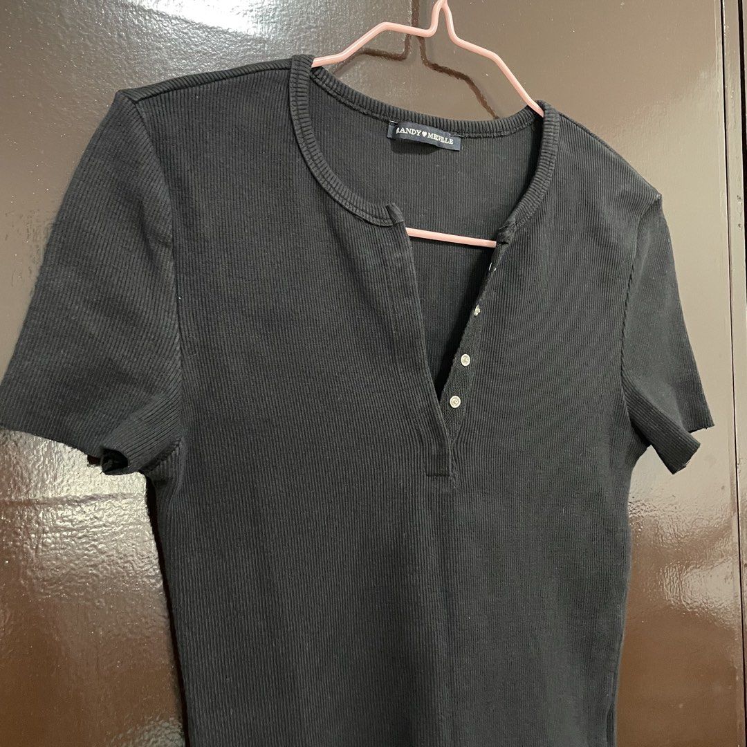Brandy Melville Black Ribbed Button-Up Top (Category: Shirts) located in Pasay City. Submitted by lovedbyzea (Listing ID 1467528382, Image 2). Description: - black in actual, not faded - Brand: Brandy Melville - Style: Black ribbed short-sleeve top with scoop neckline - Details: Split placket with silver-tone snap buttons down the front - Material: Stretchy, comfortable cotton rib fabric - Versatility: Essential basic piece that pairs easily with